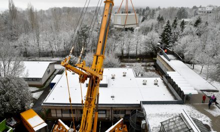 Riesenkran hebt neue Schaltanlage über Biologiegebäude